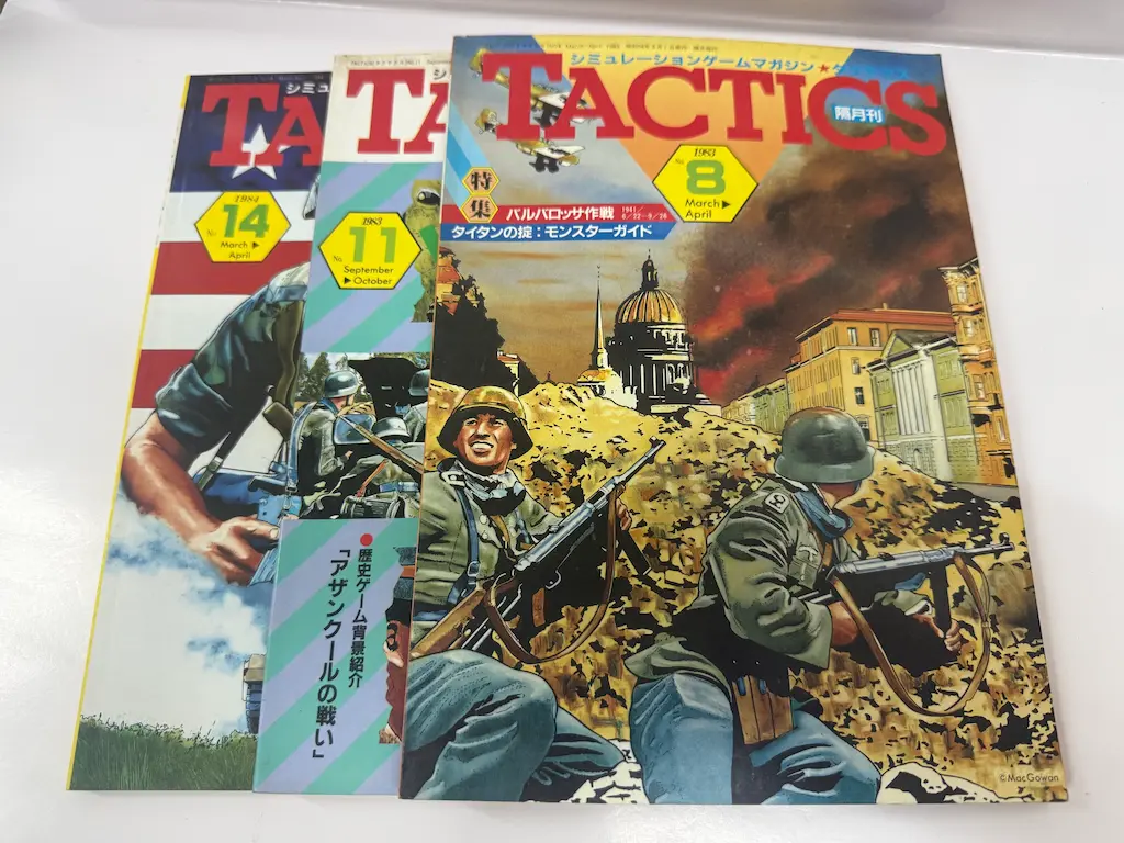 広島市安芸区でお譲りいただいた、ホビージャパンのシミュレーションゲームマガジン『TACTICS（タクテクス）』3冊を少しずつずらして重ねたところ。手前が1983年のNo.8（March-April）で、特集「バルバロッサ作戦」と「タイタンの掟：モンスターガイド」。その奥に1983年のNo.11（September-October）で「歴史ゲーム背景紹介 アザンクールの戦い」、いちばん奥が1984年のNo.14（March-April）
