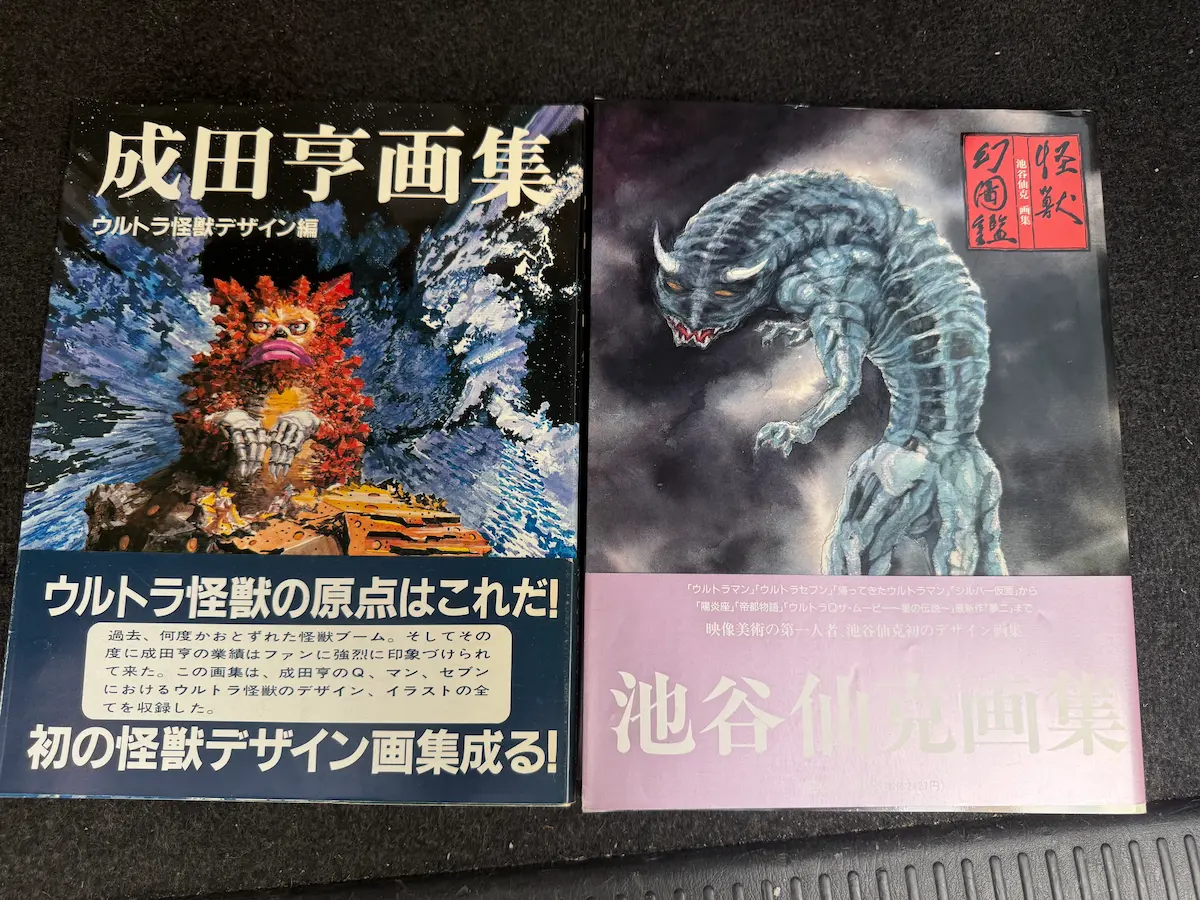 成田亨画集 ウルトラ怪獣デザイン編と、池谷仙克画集 怪獣幻図鑑の2冊を並べた状態。どちらも帯が付いており、左は青い帯に白文字、右は紫色の帯。表紙にはそれぞれ怪獣のデザイン画が印刷されている