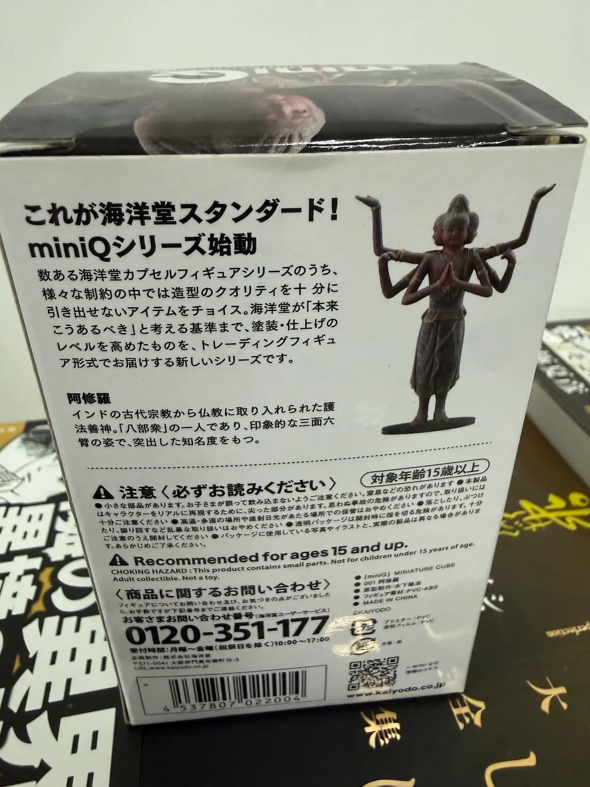 海洋堂miniQシリーズ『阿修羅』（001番）のパッケージ裏面——三面六臂の阿修羅像の写真、『これが海洋堂スタンダード!miniQシリーズ始動』のキャッチコピー、対象年齢15歳以上の表記、PVC-ABS素材、MADE IN CHINAなどの商品仕様