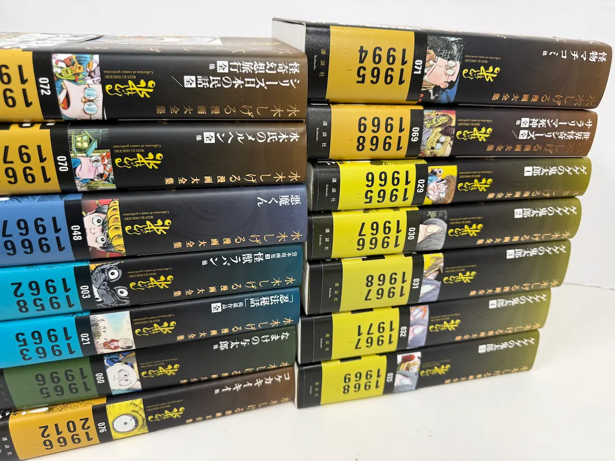 講談社『水木しげる漫画大全集』の背表紙群——ゲゲゲの鬼太郎1〜5（029〜033巻）、悪魔くん、墓場鬼太郎、シリーズ日本の民話・怪奇幻想旅行全、水木氏のメルヘン全集、なまけの与太郎、怪物マチコ、サラリーマン死神など、黄色ラベルに巻数と年代表記が並ぶ
