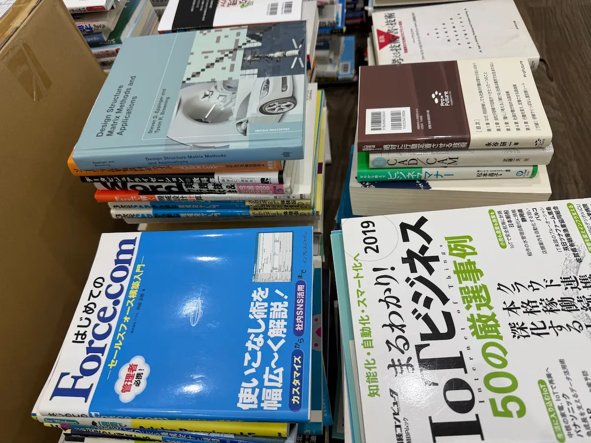 Design Structure Matrix Methods and Applications、はじめてのForce.com、IoTビジネス50の厳選事例など、技術書とビジネス書が積まれている様子