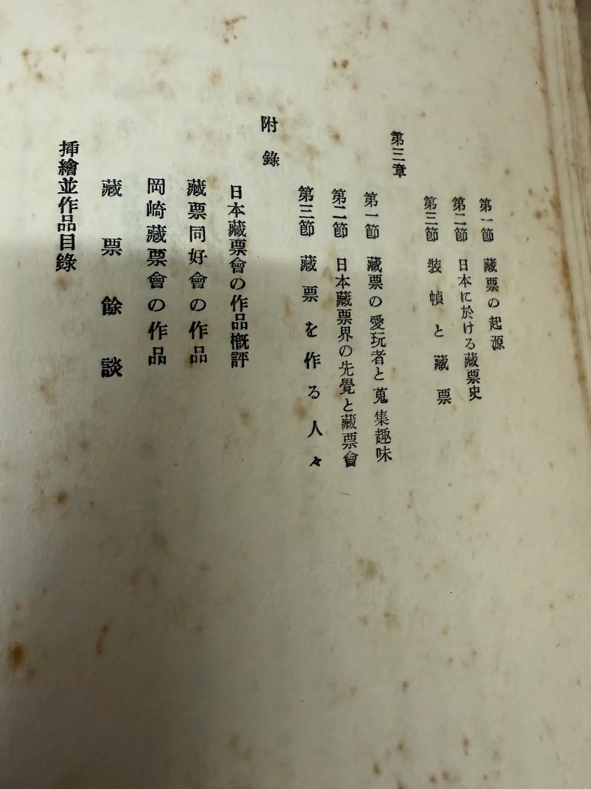 齋藤昌三『藏書票の話』の目次ページ。上段に第二章「藏書票の起源」「日本に於ける藏票史」「裝幀と藏票」、第三章「藏票の愛玩者と蒐集趣味」「日本藏票界の先覺と藏票會」「藏票を作る人々」、附録に「日本藏票會の作品概評」「藏票同好會の作品」「岡崎藏票會の作品」「藏票餘談」「挿繪並作品目録」の章立てが縦書きで印刷されている