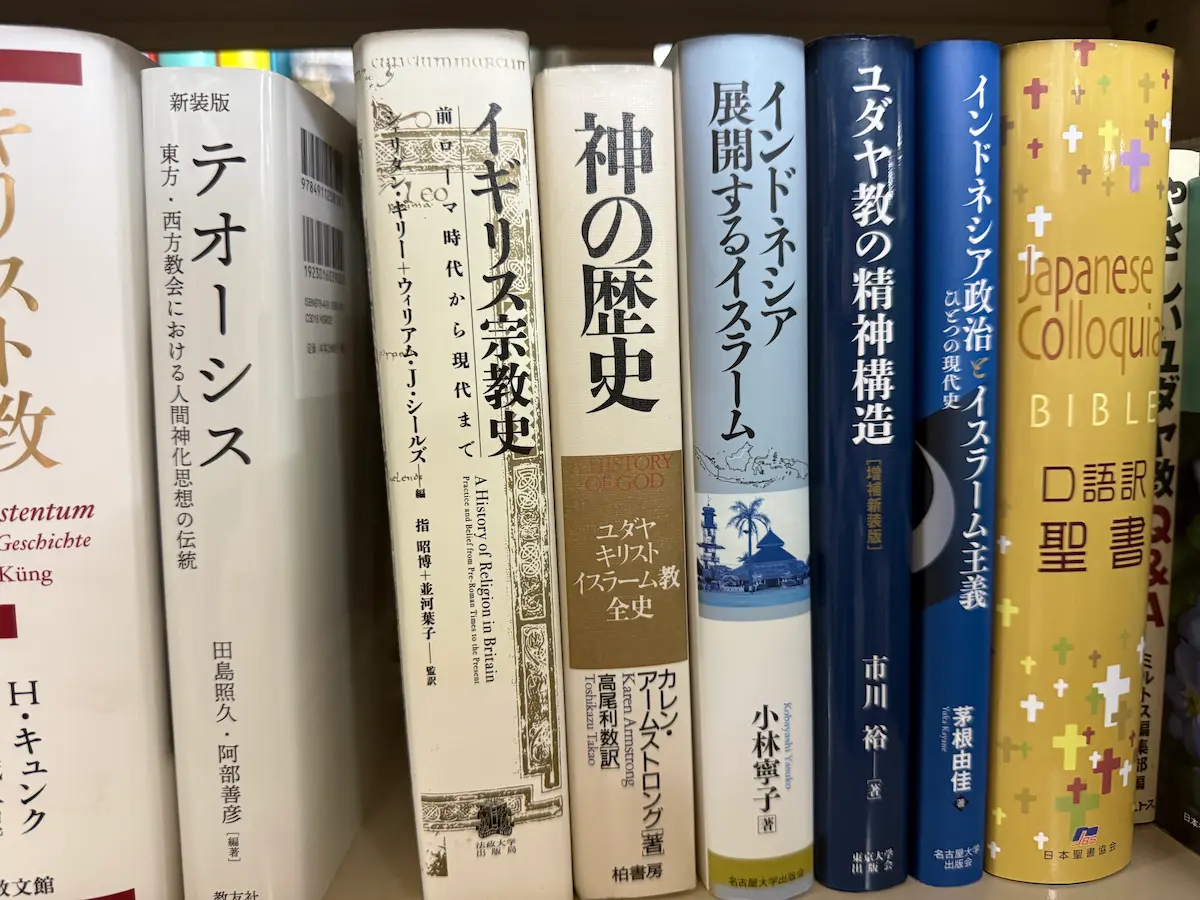 ハンス・キュンク『キリスト教』、田島照久・阿部善彦編『テオーシス』、指昭博・並河葉子監訳『イギリス宗教史』、カレン・アームストロング『神の歴史 ユダヤ・キリスト・イスラーム教全史』、小林寧子『インドネシア 展開するイスラーム』、市川裕『ユダヤ教の精神構造』、茅根由佳『インドネシア政治とイスラーム主義』、日本聖書協会『口語訳聖書』が同居する書棚の一段